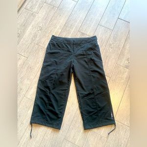 Women Nike Versatile Pant. Button top, pockets, Capri length. Size M